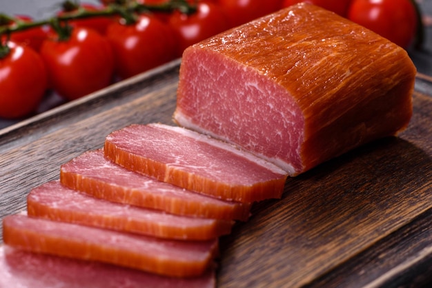 Delicious smoked meat cut with slices on a wooden cutting board