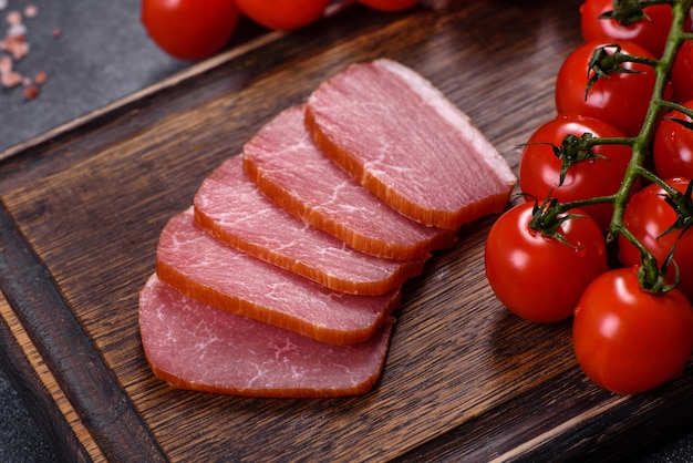 Deliziosa carne affumicata tagliata a fette su un tagliere di legno