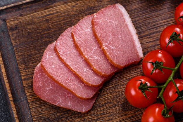 Delicious smoked meat cut with slices on a wooden cutting board