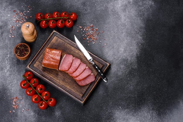 Deliziosa carne affumicata tagliata a fette su un tagliere di legno