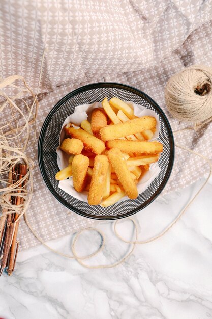 Delicious snack plate, french fries, onion rings, spring rolls or sausages on the table