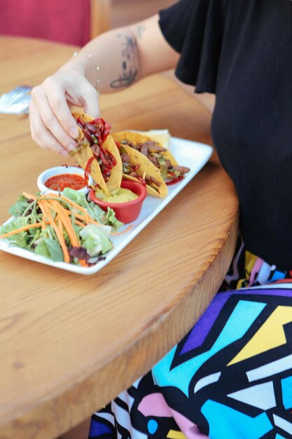 Delicious snack plate, french fries, onion rings, spring rolls\
or sausages on the table