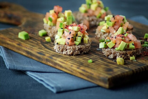 Delicious snacks with bread avocado and tomato on the board The concept of healthy food