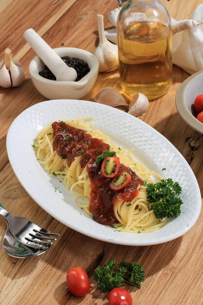 Delicious Spaghetti Served on White Oval Plate. On the Wooden Table