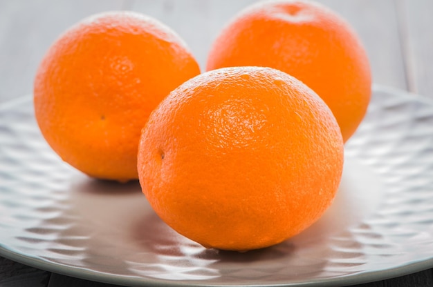 Delicious spanish orange on a wooden table one cut in halffresh juicy oranges on the table