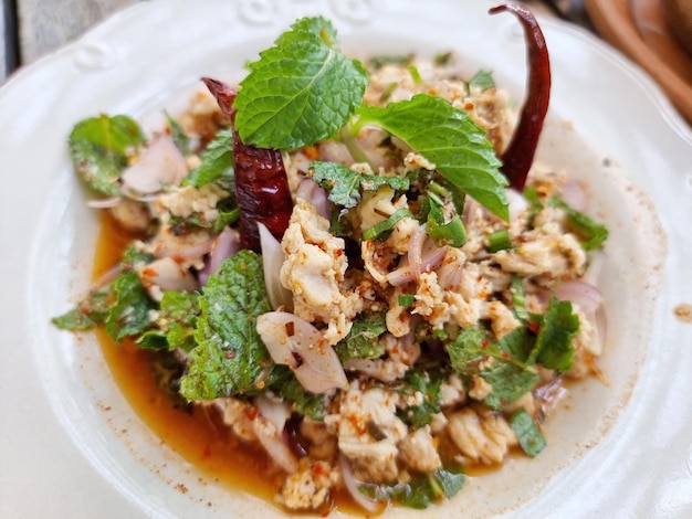 Delicious Spicy Minced Chicken Salad on a wooden table