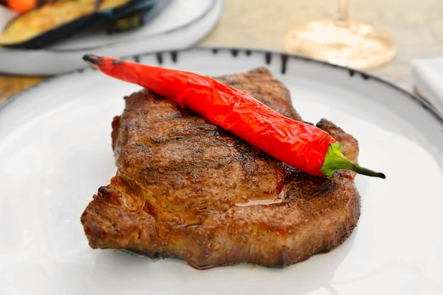 Delicious steak served with chili pepper on plate