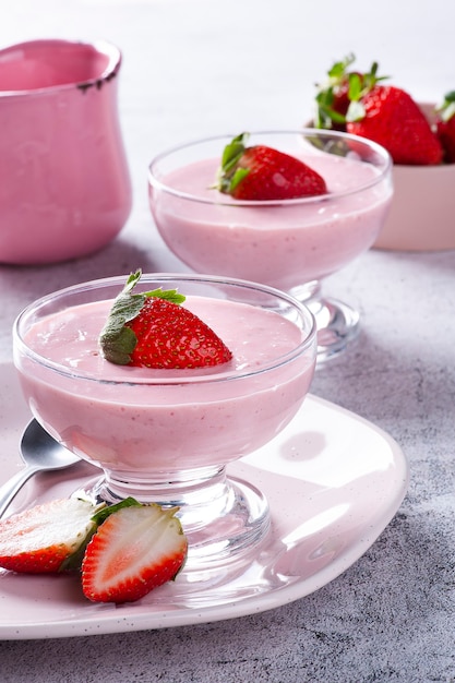 Delicious strawberry mousse in glass bowl with fresh strawberries.