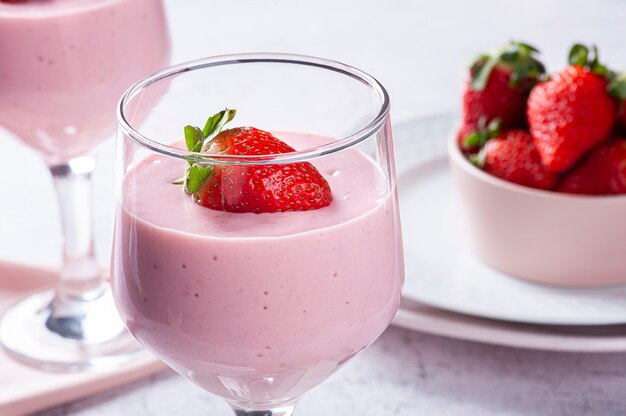 Delicious strawberry mousse in glass bowl with fresh strawberries.