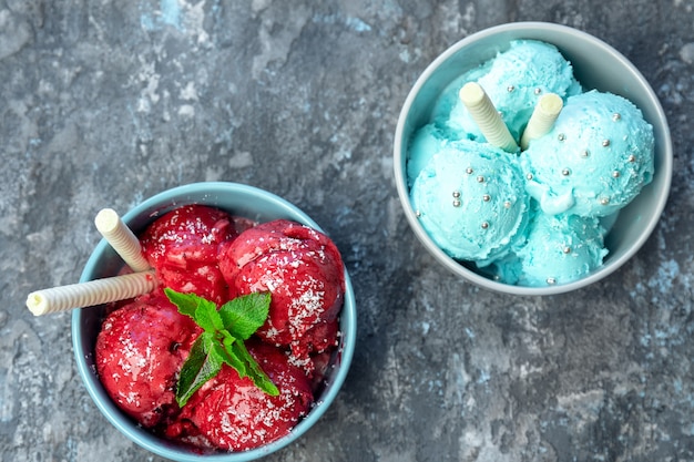 Delicious strawberry and Pistachio ice cream with waffle sticks, several leaves of mint in two bowls