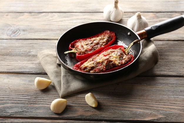 Delicious stuffed peppers in frying pan on table closeup