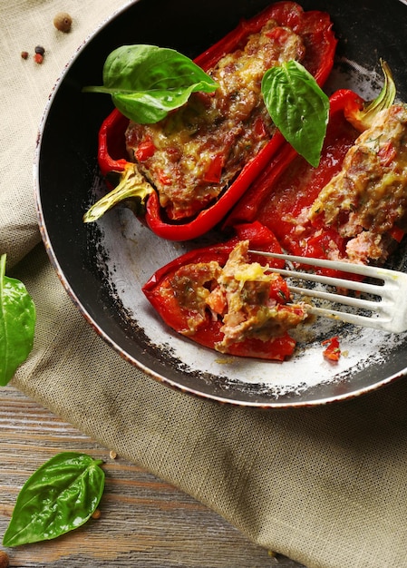 Delicious stuffed peppers in frying pan on table closeup