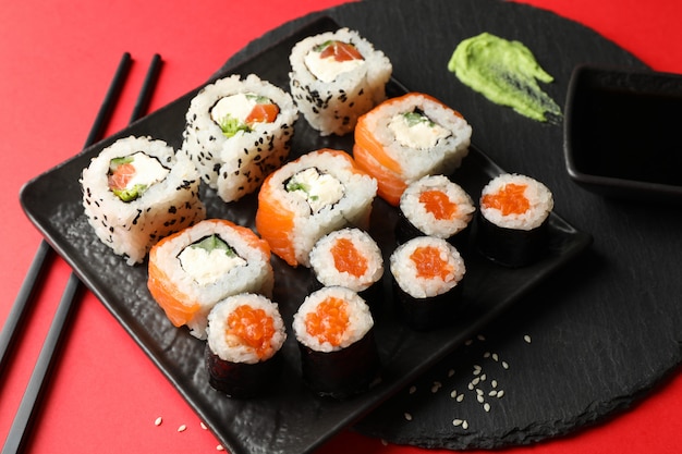 Delicious sushi rolls on red surface. Japanese food