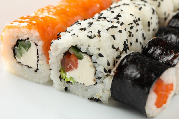 Delicious sushi rolls on white plate, close up. Japanese food