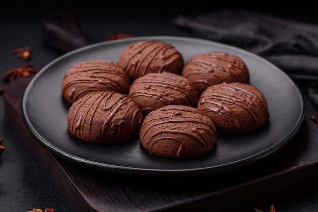 Delicious sweet chocolate cookies on a black ceramic plate