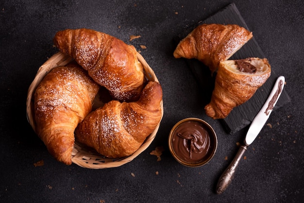 Delicious sweet croissant with chocolate on dark background