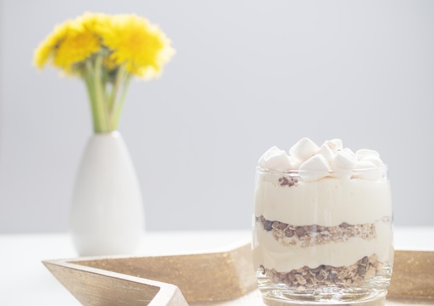 Delicious sweet dessert with cream in a glass on a light background a beautiful breakfast