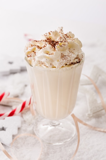 Delicious sweet drink in glass on snow