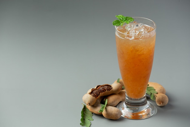 Photo delicious sweet drink tamarind juice on gray surface