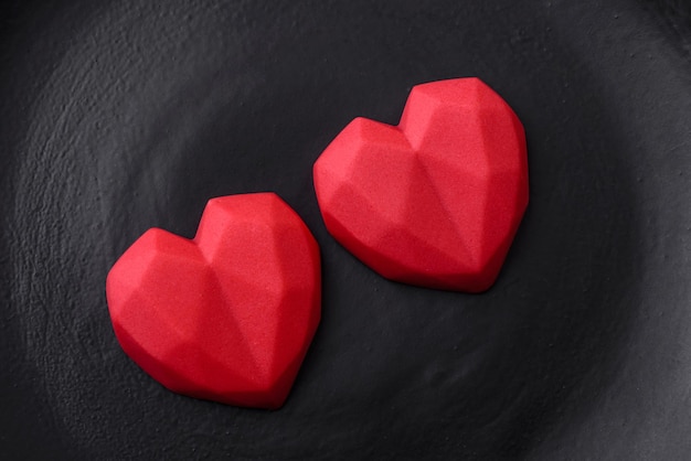 Delicious sweet heart shaped chocolate candies on a dark concrete background