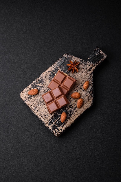 delicious sweet milk chocolate broken into cubes on a wooden cutting board