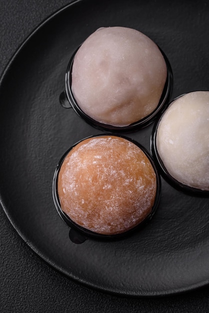 Delicious sweet mochi dessert with toppings on a dark concrete background