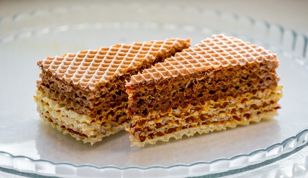 Biscotti dolci deliziosi del wafer su una lastra di vetro_