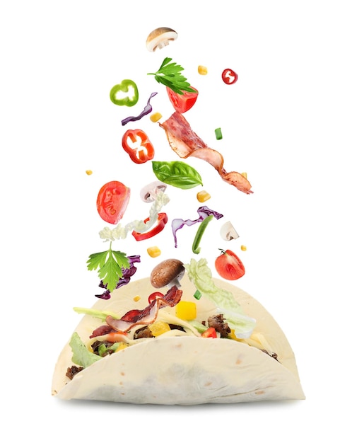 Delicious tacos Ingredients falling into tortilla on white background