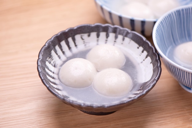 Delicious tang yuan yuanxiao in a small bowl traditional\
festive food rice dumplings ball with stuffed fillings for chinese\
lantern festival close up