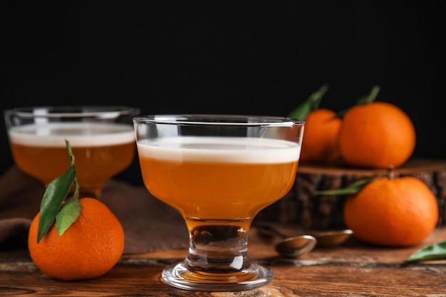 Delicious tangerine jelly in glass bowl on wooden table closeup