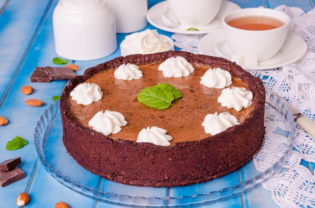 Delicious Tart with chocolate cream, cherry, whipped cream and mint leaves on top.