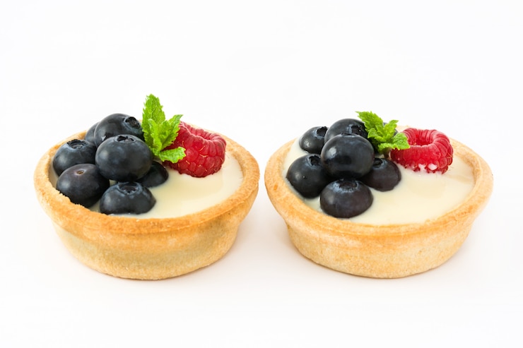 Фотография вкусная корзиночка с малиной и черникой на белом столе