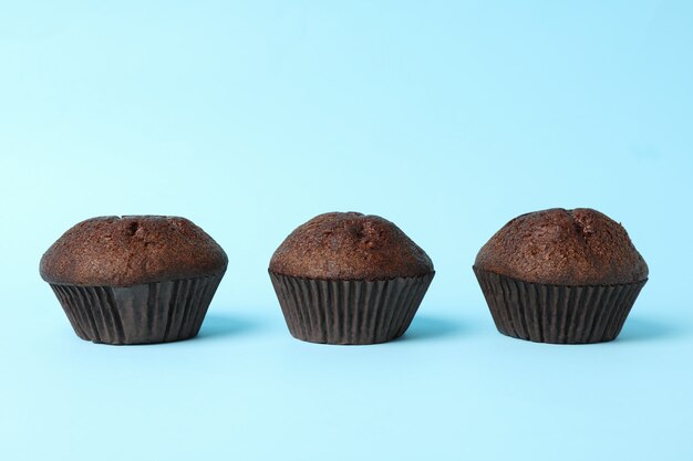 Photo delicious tasty chocolate muffins on blue background