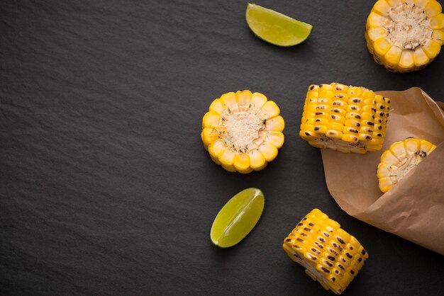 Delicious tasty grilled corn on black stone background.