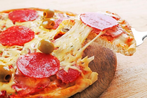 Delicious tasty pizza with cut slice closeup