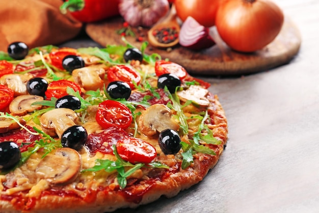 Delicious tasty pizza with ingredients on wooden table