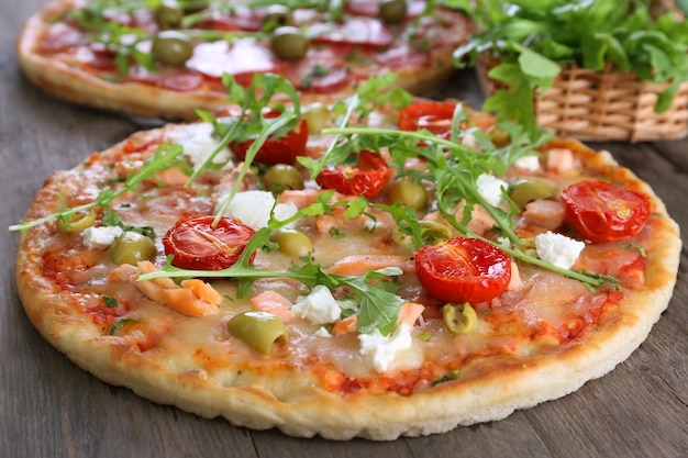 Delicious tasty pizzas with ingredients on table closeup