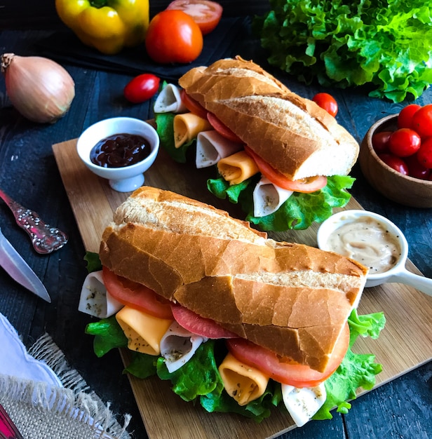 Panini deliziosi e gustosi con tacchino, prosciutto, formaggio, pomodori