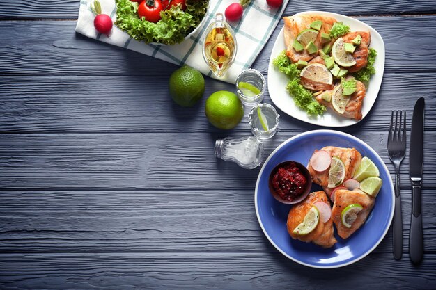 Delicious tequila lime chicken with ingredients on wooden background