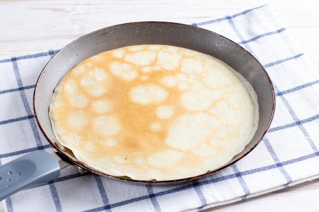 Delicious thin pancake in frying pan