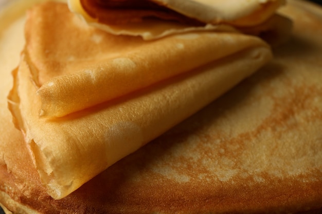 Delicious thin pancakes on whole background, close up