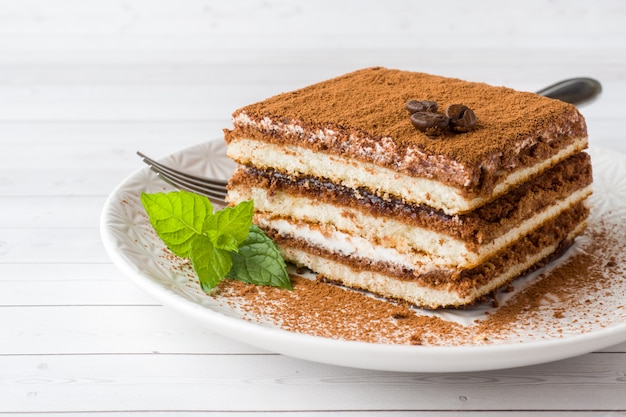 Delicious Tiramisu cake with coffee beans and fresh mint 