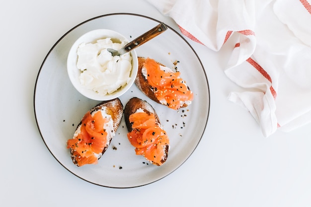 Delicious toast sandwich with salmon and cheese cream on a white plate.