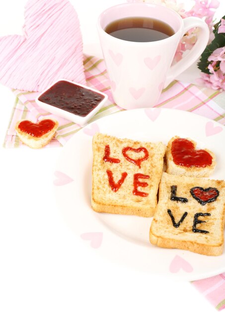 Delicious toast with jam and cup of tea on table close-up