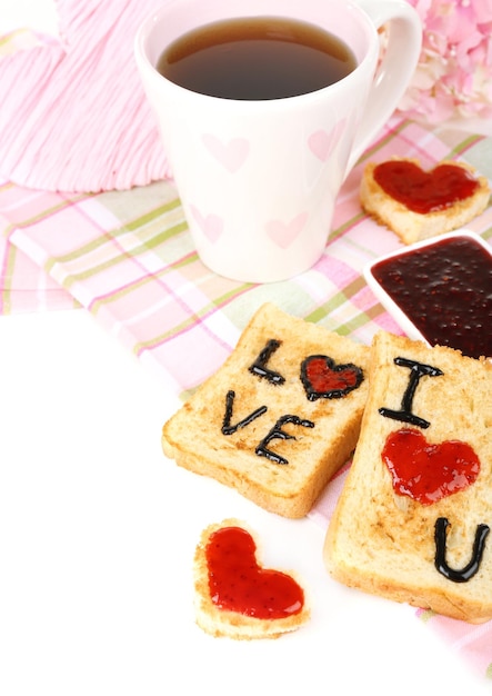 Delicious toast with jam and cup of tea on table close-up