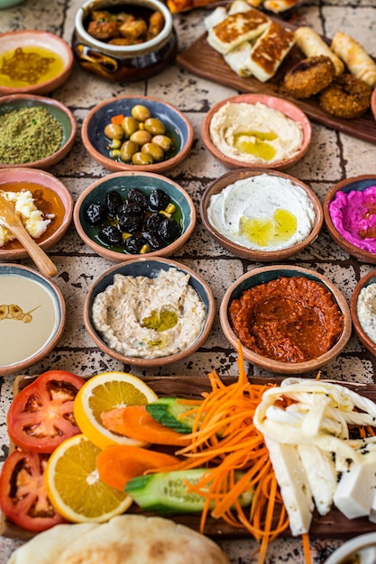 Delicious Turkish family breakfast table with pastries, vegetables, greens, spreads, cheeses, fried eggs, jams. Top view.