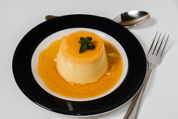 Вкусный типичный десерт из Южной Америки под названием Flan, приготовленный из яиц, молока, ванили и приправленный карамелью. Этническая еда и концепция горячего питания.