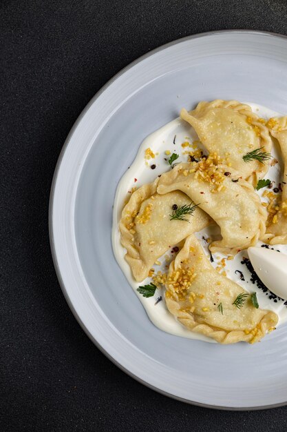 delicious Ukrainian dumplings with sauce on a plate