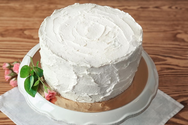 Delicious vanilla cake with whipped cream on table