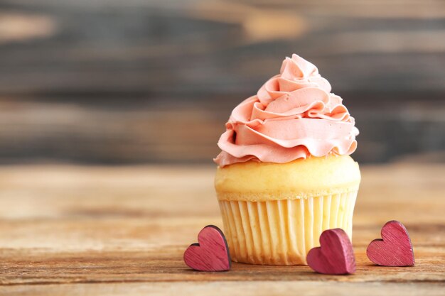 Delicious vanilla cupcake on table